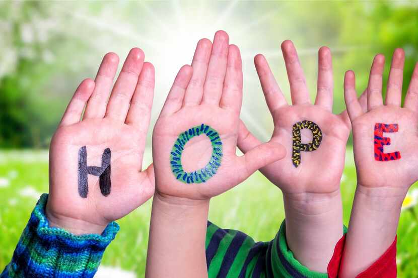 Children's hands painted with letters that spell HOPE.