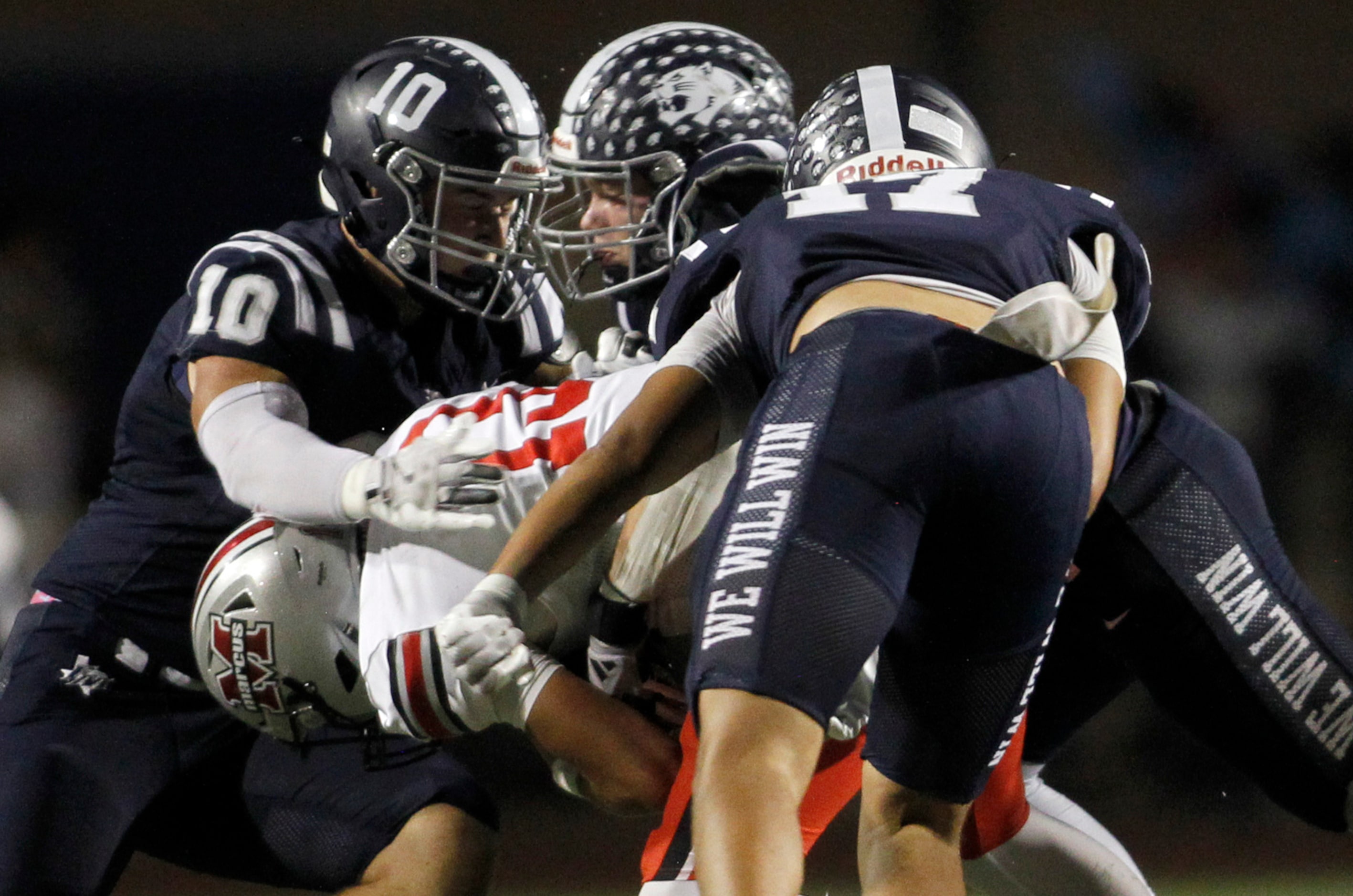 Flower Mound Marcus quarterback Colton Nussmeier (13), lower left, is swarmed in the...