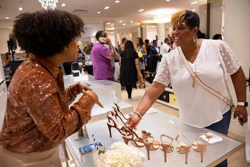 Designer Salone Monet, left, talks to customer Judy Garner at the Black Fashion Movement...
