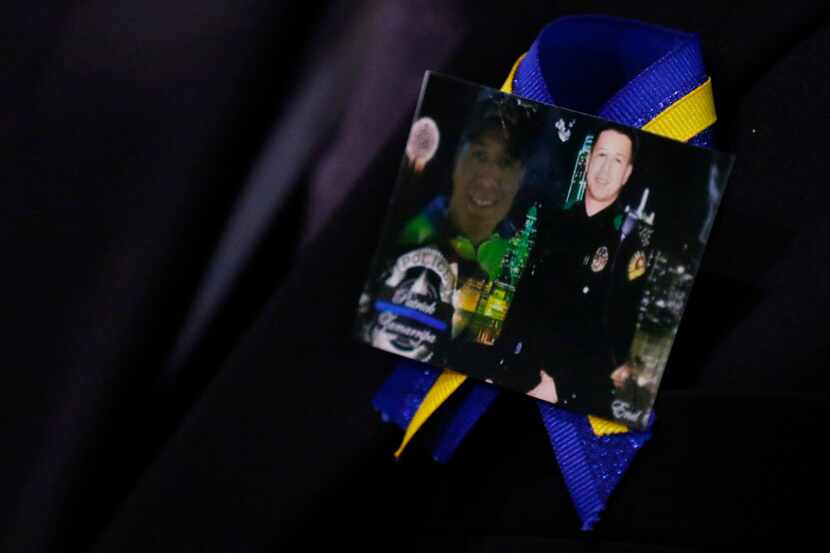 A family member wears a ribbon with photos of Patrick Zamarripa during a funeral service for...