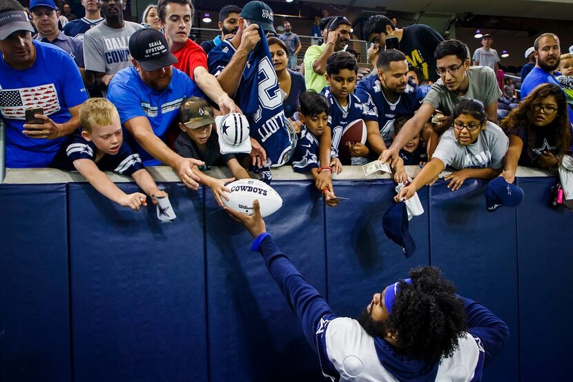 Dallas Cowboys running back Ezekiel Elliott (21) signs autographs for fans after the team's...