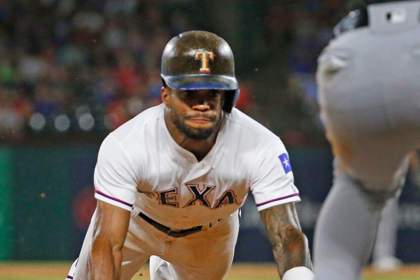 Texas Rangers left fielder Delino DeShields (3) slides into third on a stolen base during...