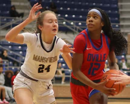 Duncanville guard Kaylinn Kemp (12), right, drives to the basket against the defense of...