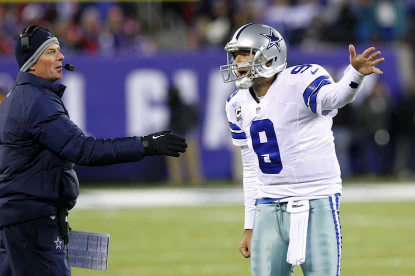 Dallas Cowboys quarterback Tony Romo (9) and head coach Jason Garrett have a quick...