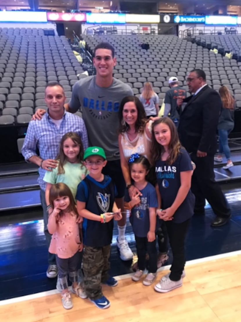 Dwight Powell poses after the home opener Saturday with the family of a cancer patient at UT...