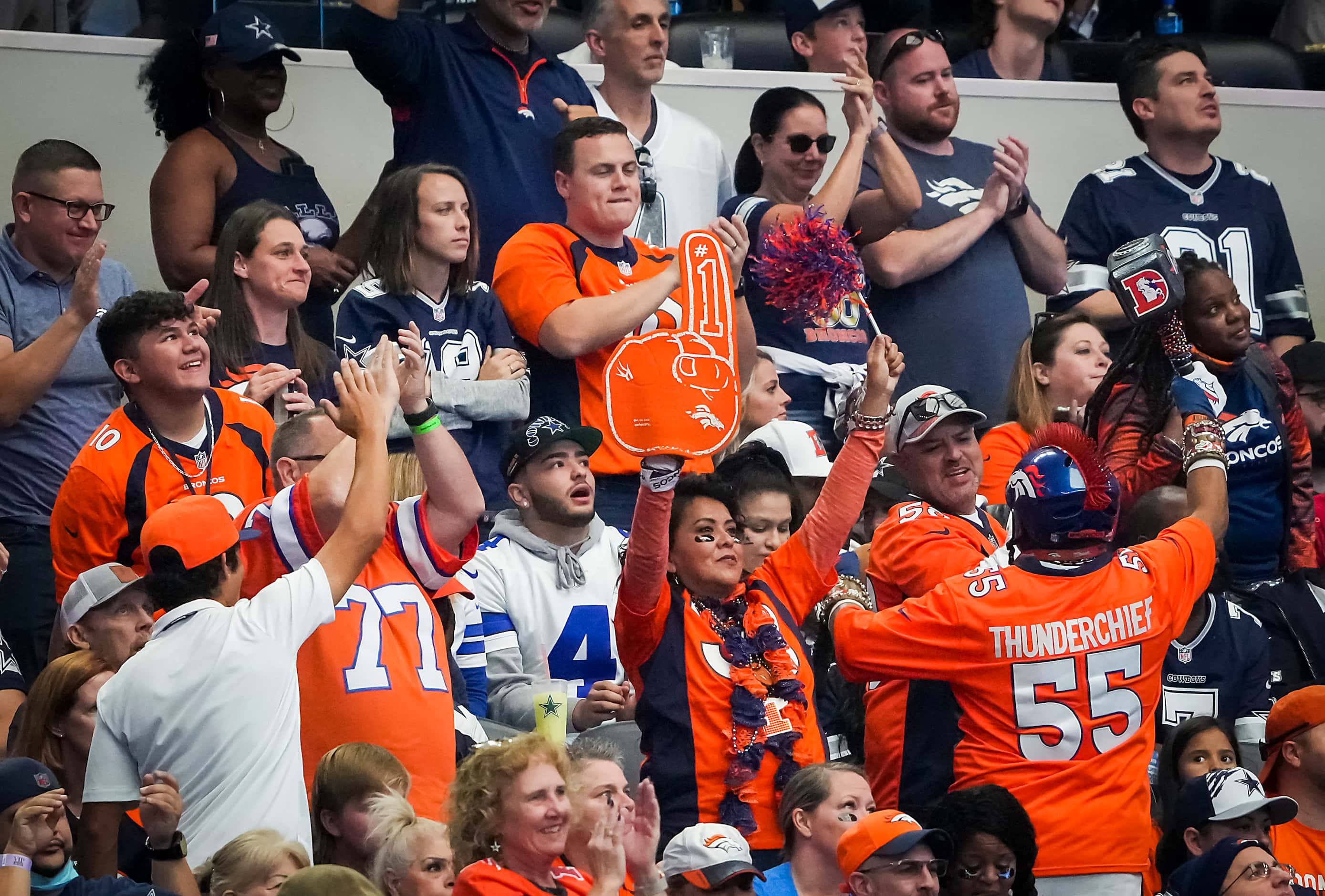 Denver Broncos fans cheer a touchdown as Dallas Cowboys look on during the first half of an...