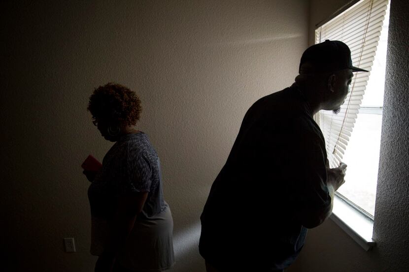 Kenneth Davis (right) looks out of blinds in the master bedroom as he and his wife, Janice...