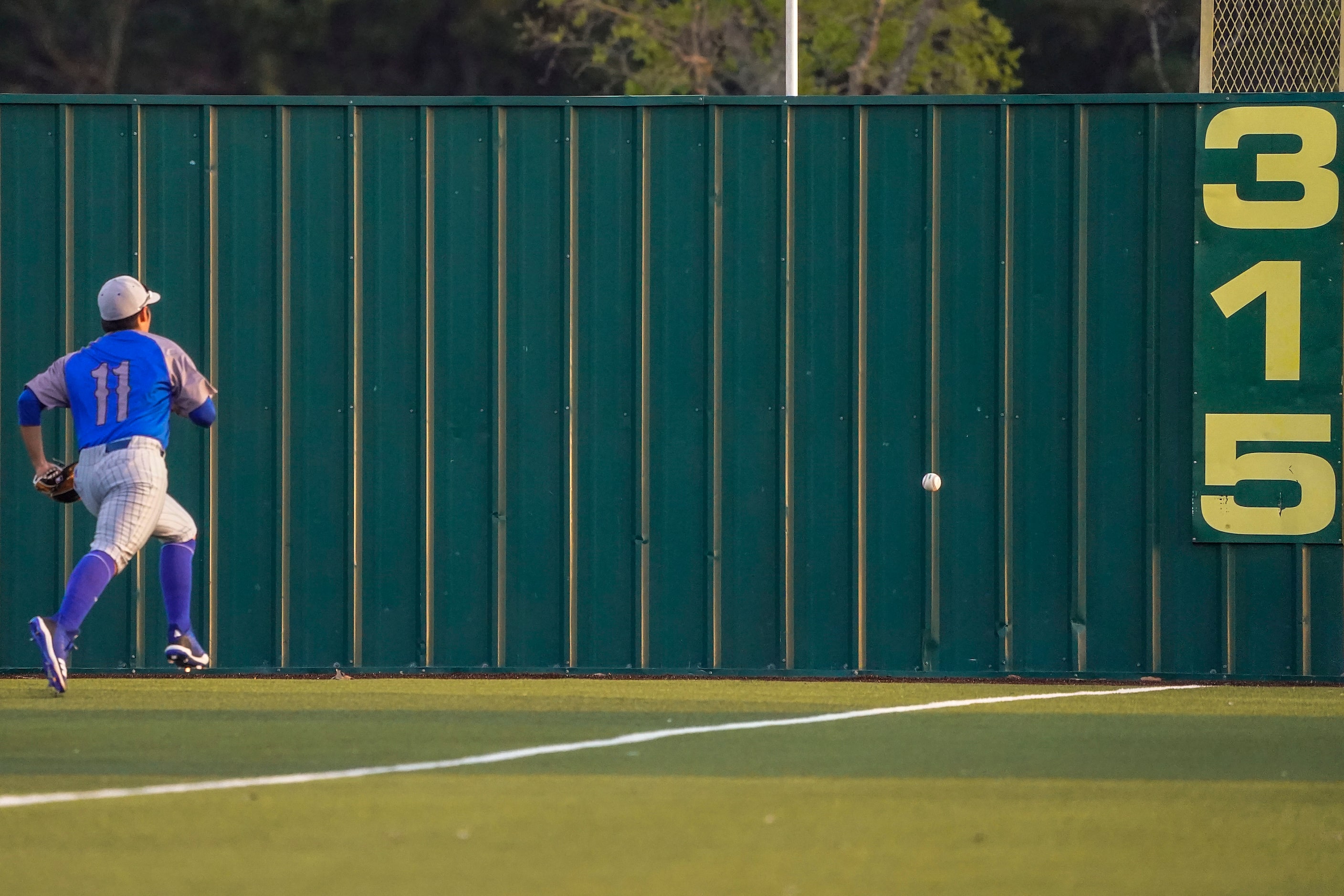 North Mesquite right fielder Julio Corrales chases a triple off the bat of Rockwall-Heath...