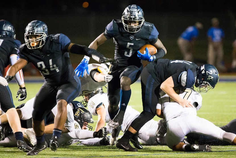 Wylie East quarterback  Eno Benjamin (5) gets blocks from Jordan Jeffrey (34) and Michael...