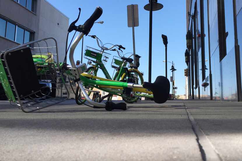 STOCK - A LimeBike lies on a sidewalk on Harwood St in downtown Dallas, Texas on December...