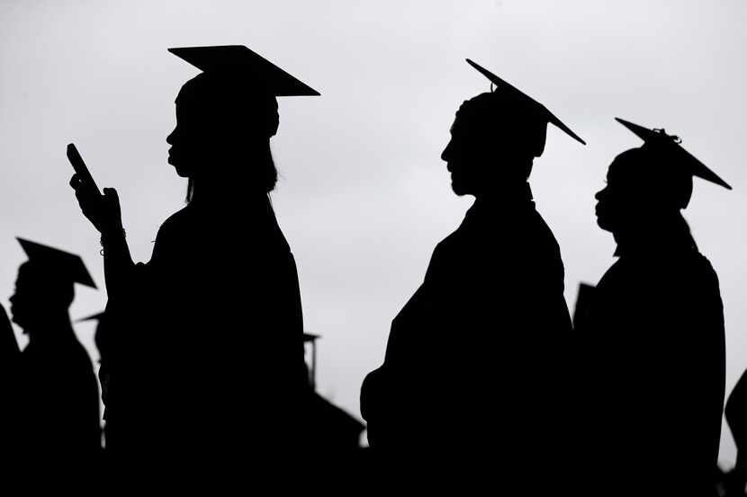 New graduates line up before the start of a community college commencement.