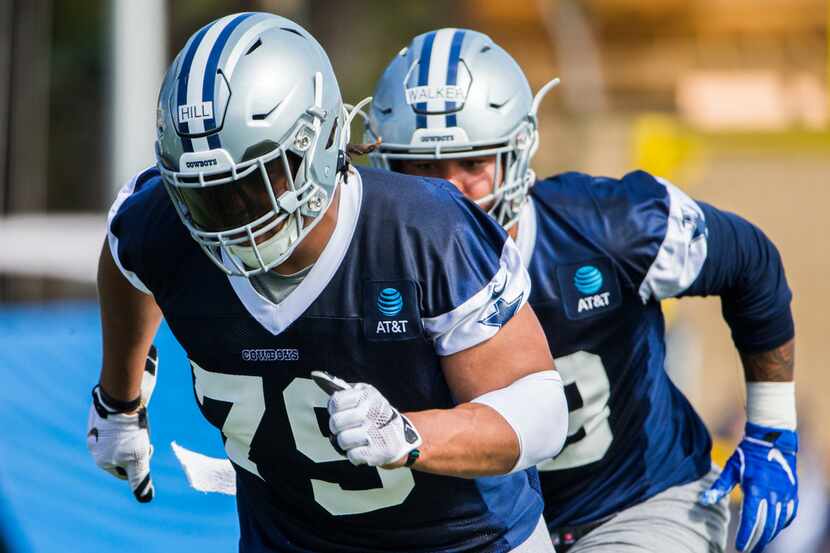 Dallas Cowboys defensive tackle Trysten Hill (79) and tight end Dalton Schultz (86) run a...