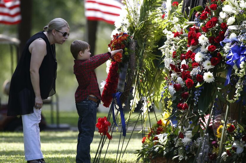 Katrina Ahrens, wife of fallen Dallas police officer Lorne Ahrens, watches her son Magnus...