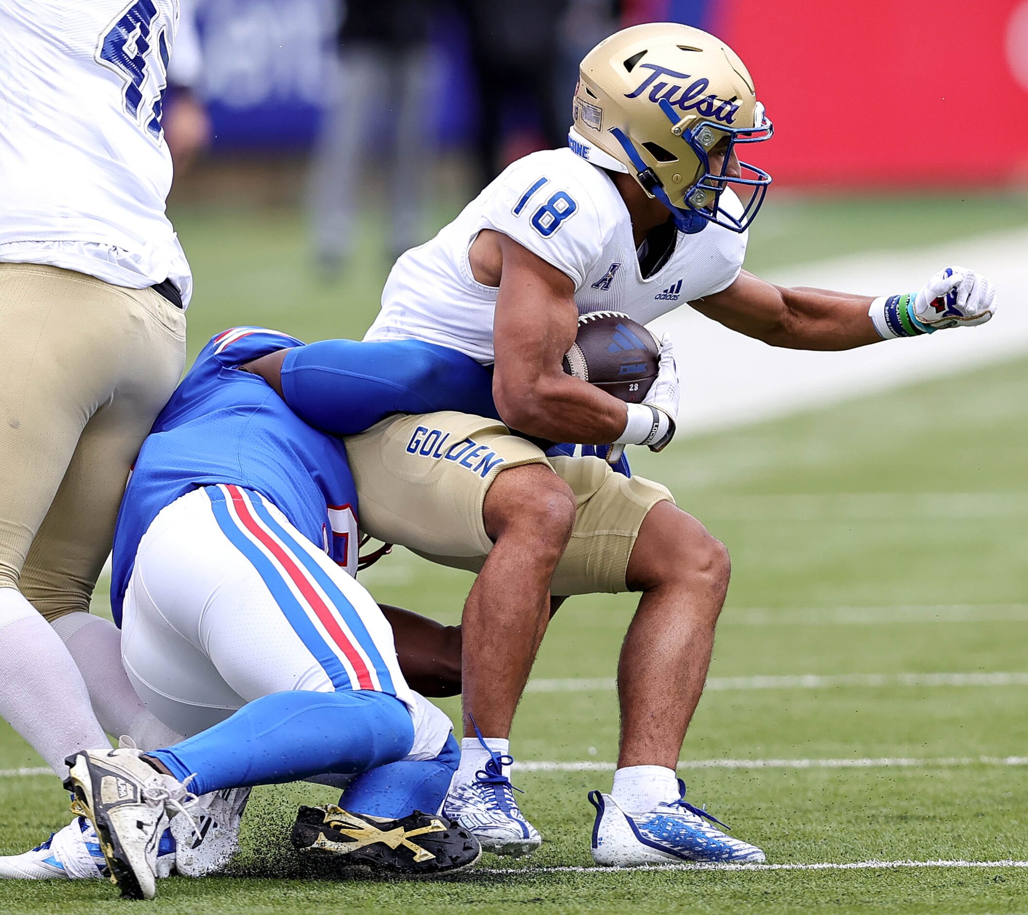 SMU defensive end Nelson Paul (left) drags down Tulsa wide receiver Kamdyn Benjamin (18)...