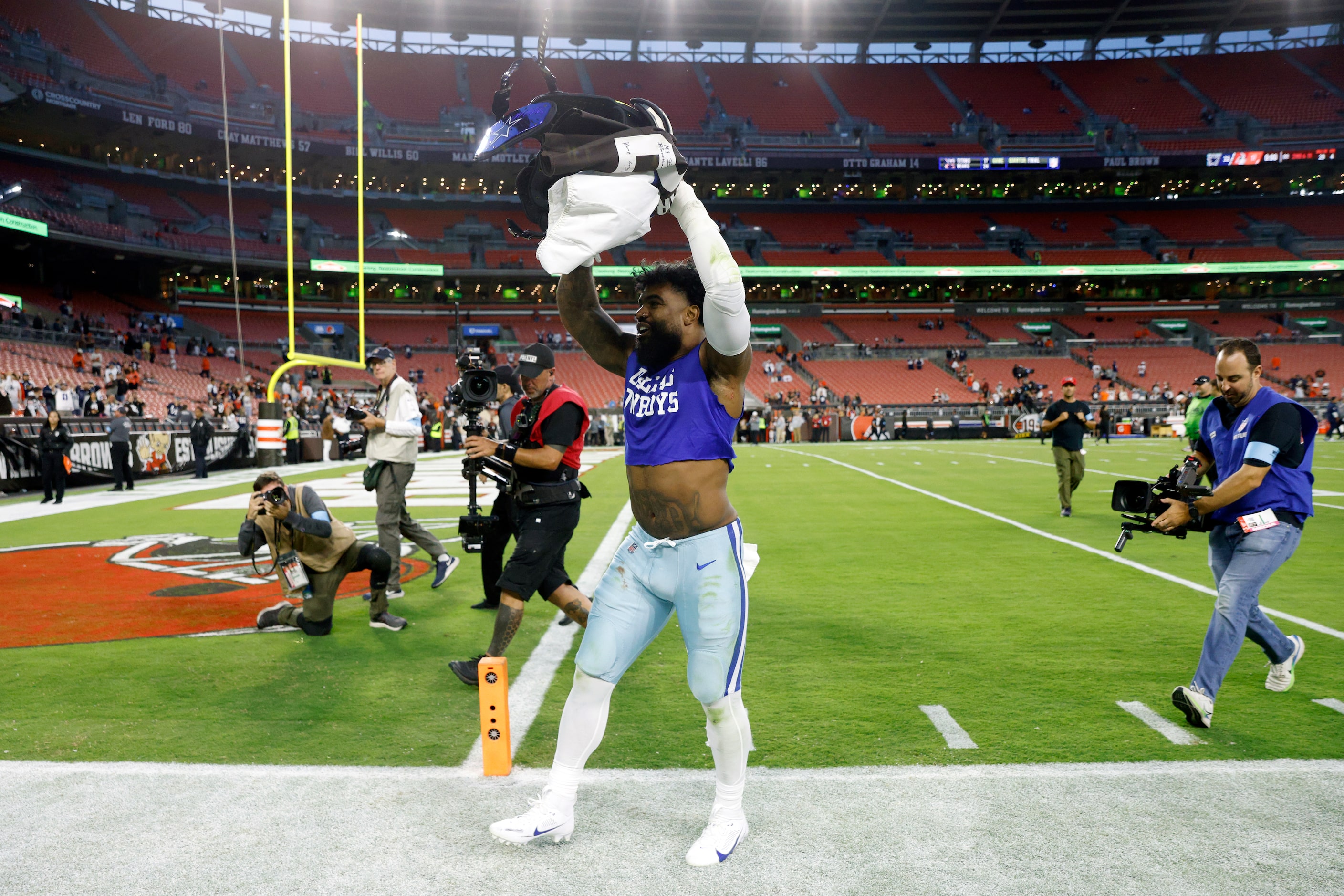 Dallas Cowboys running back Ezekiel Elliott cheers as he runs off the field after a game...