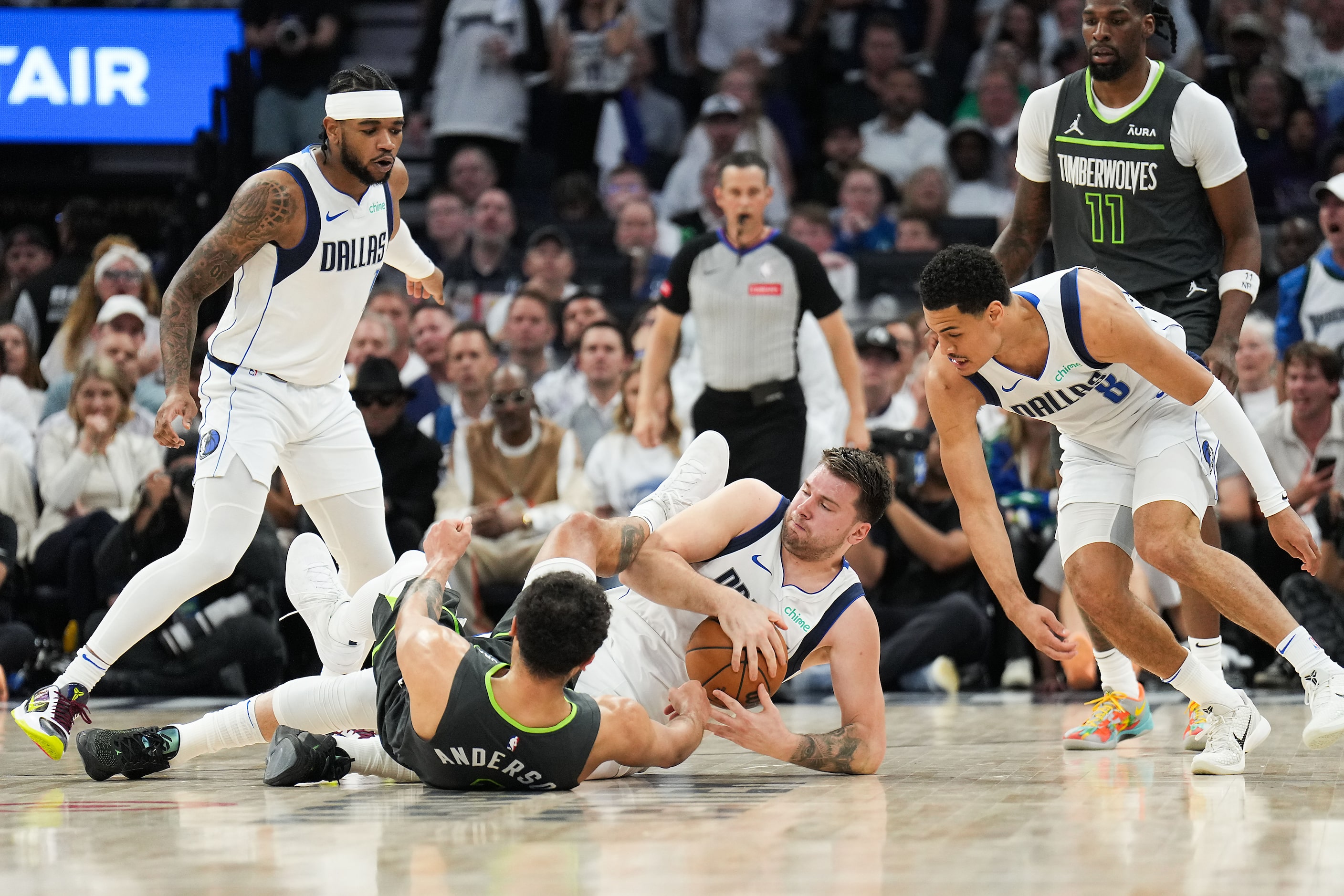 Dallas Mavericks guard Luka Doncic (77) wrestles a loose ball away from Minnesota...