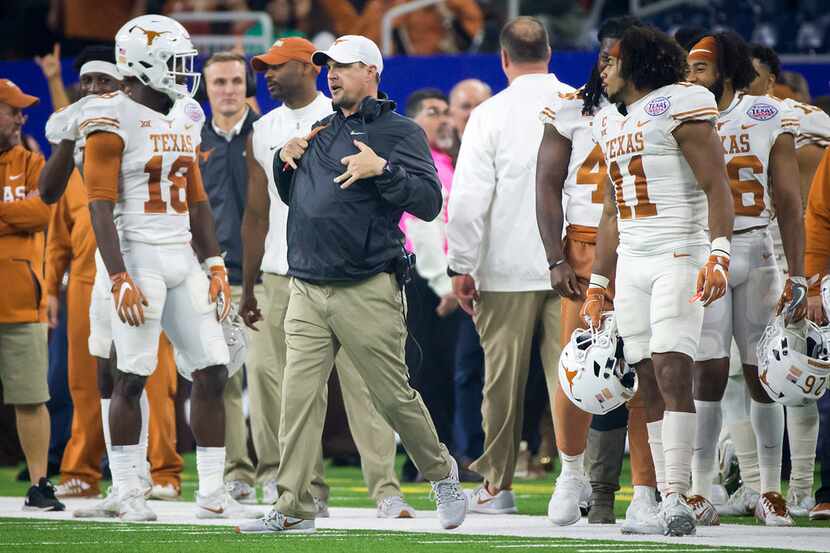 Texas head coach Tom Herman celebrates with his players during the final minute of a win...