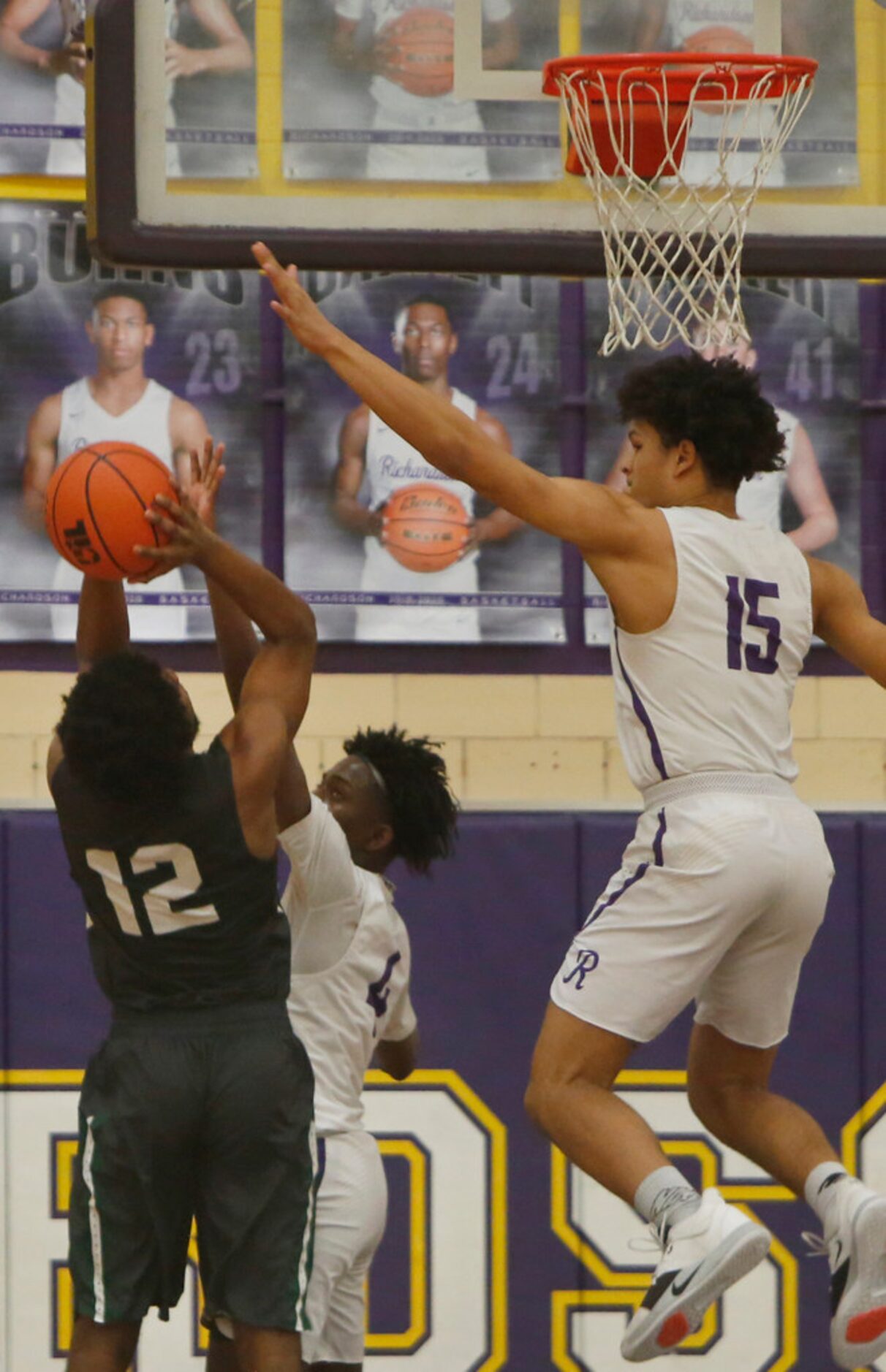 Richardson Berkner's Micah Law (12) is challenged as he shoots by Richardson defenders...