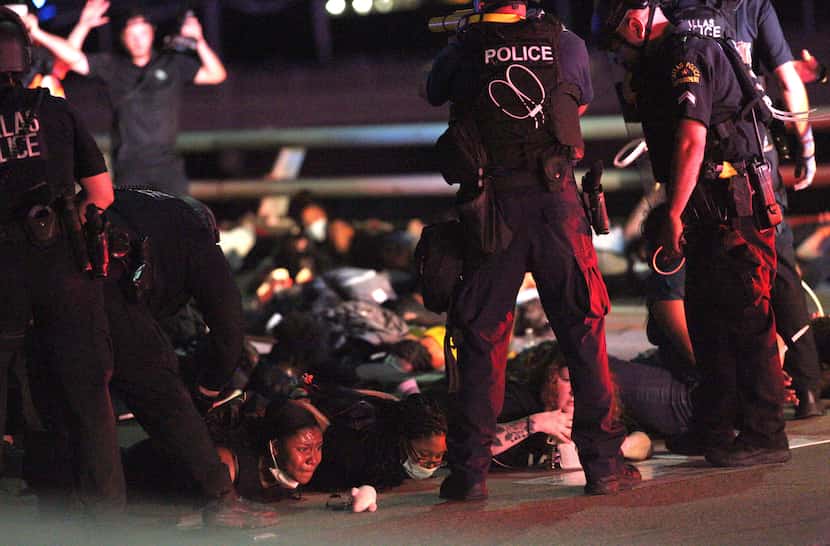 Police forced protesters to lie on the ground on the Margaret Hunt Hill Bridge while making...