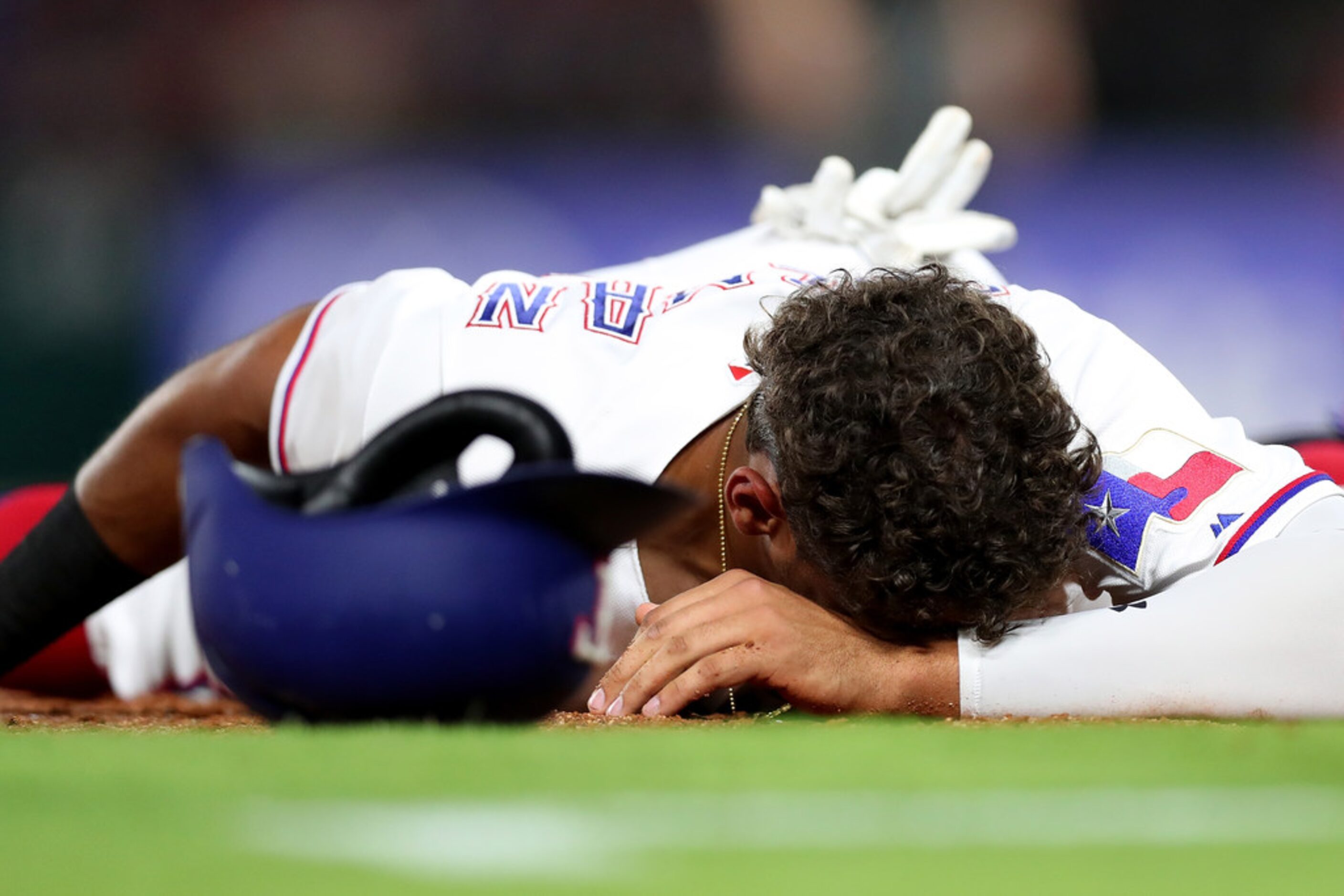 ARLINGTON, TX - JUNE 25:  Ronald Guzman #67 of the Texas Rangers reacts after colliding with...