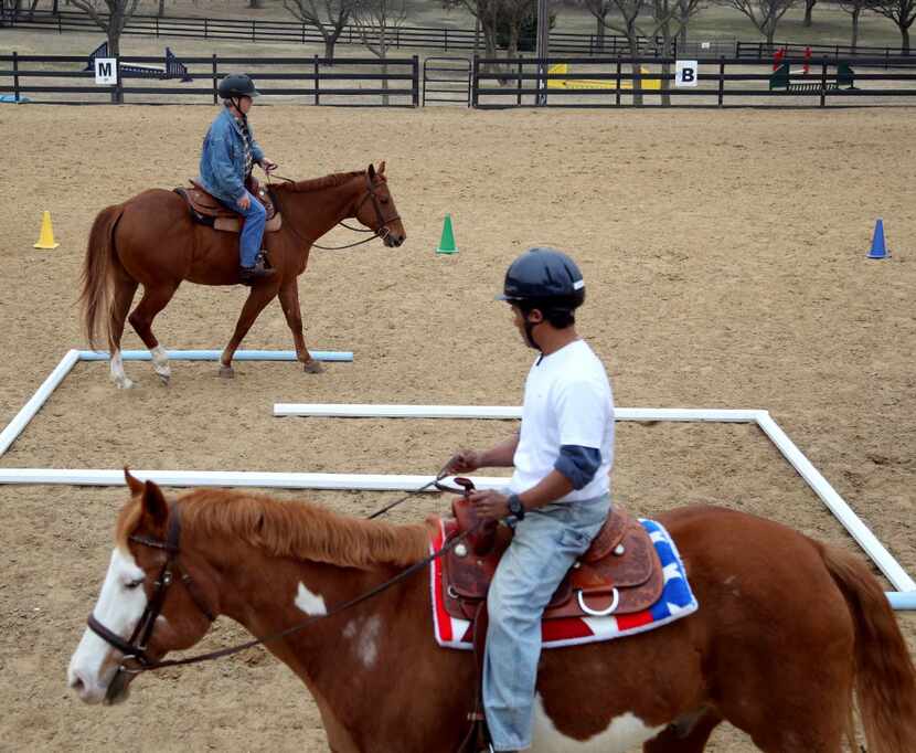 Army veterans Kurt Hughett, top, and Aldy Saturnino went through a set of obstacles during a...