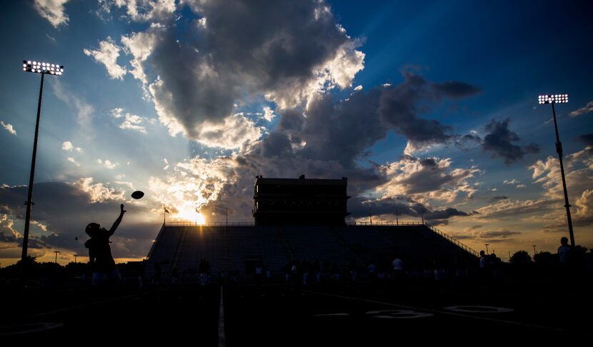 A Lancaster football player catches a pass during warmups before their game against...