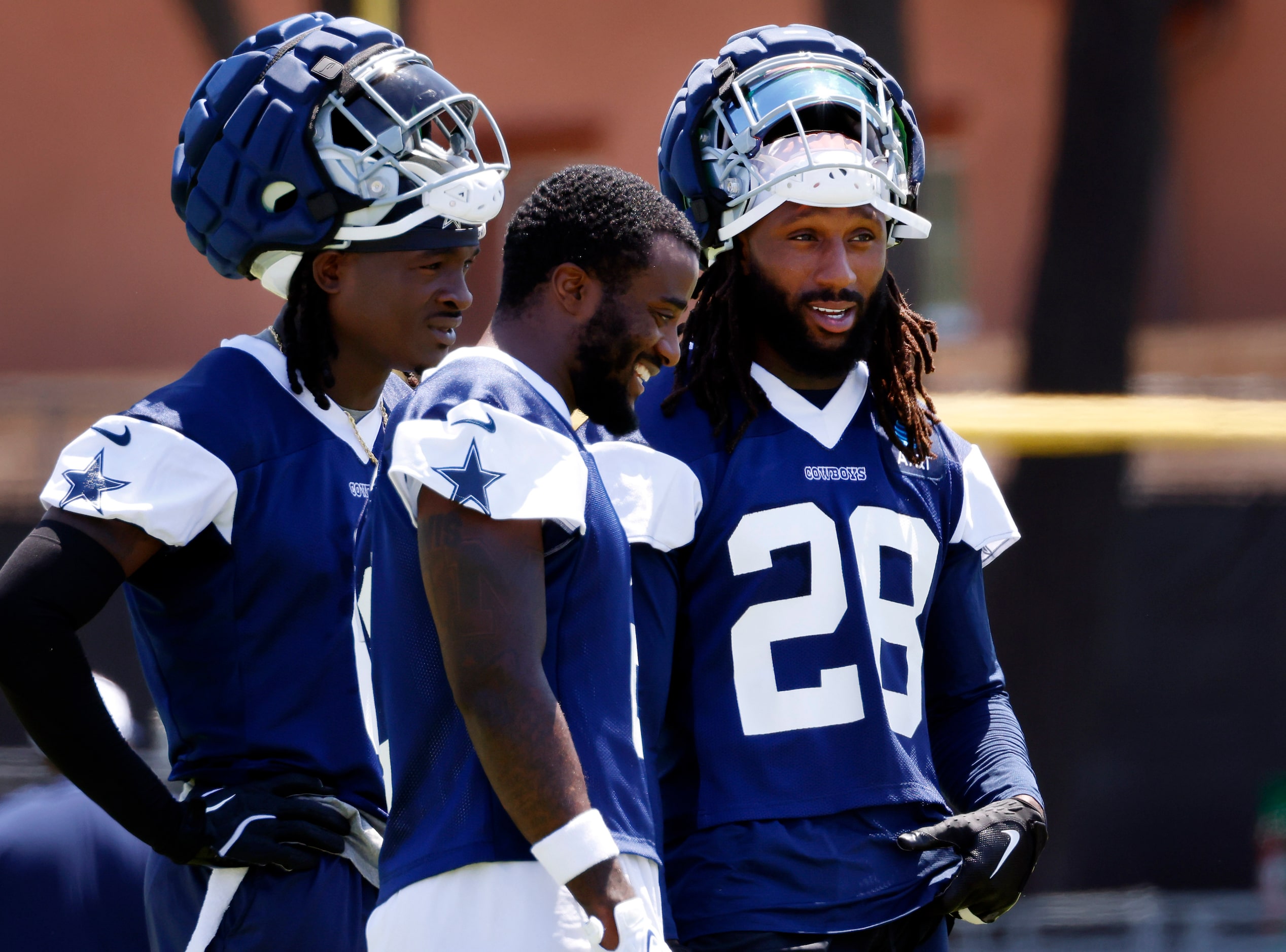 Dallas Cowboys safety Malik Hooker (28) visits with teammate Jourdan Lewis (center) during a...