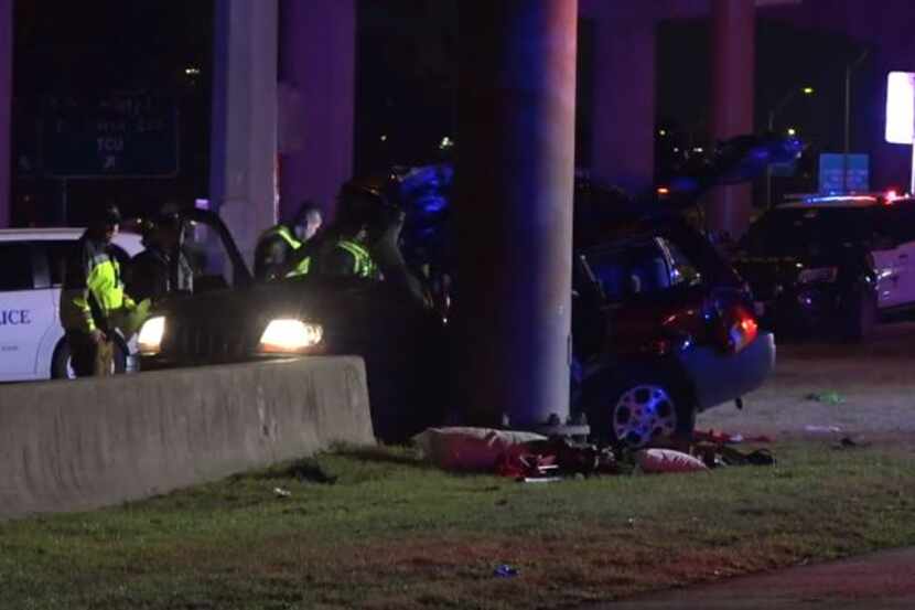 Fort Worth police examine an SUV that struck a sign pillar Wednesday night in a crash that...