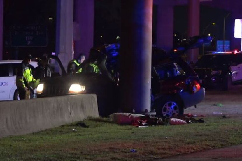 Fort Worth police examine an SUV that struck a sign pillar Wednesday night in a crash that...
