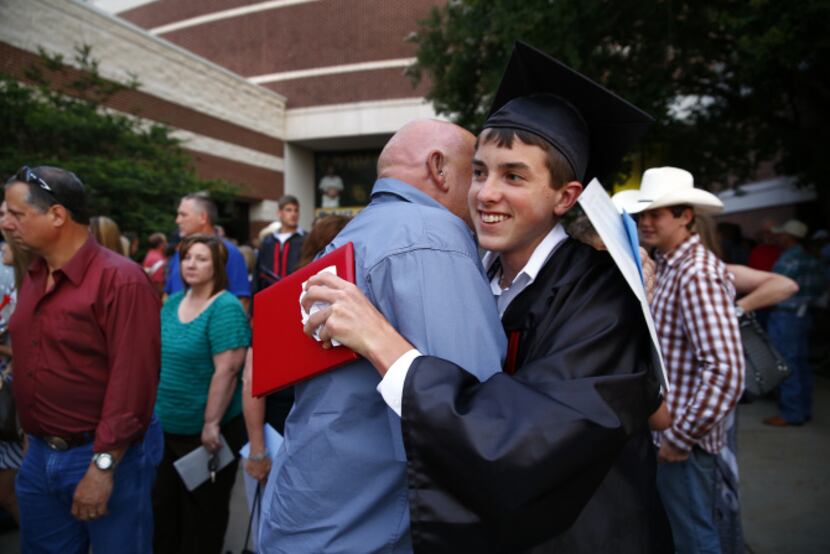 West High graduate Justin Klaus is congratulated by his grandfather Jimmy Walker after...