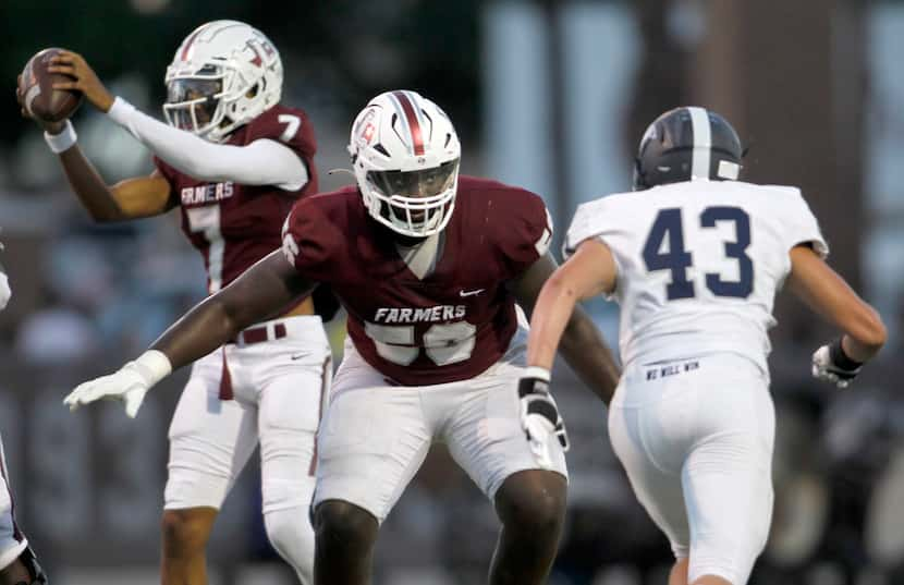 Lewisville offensive lineman Michael Fasusi (56), center, protects quarterback Ethan Terrell...