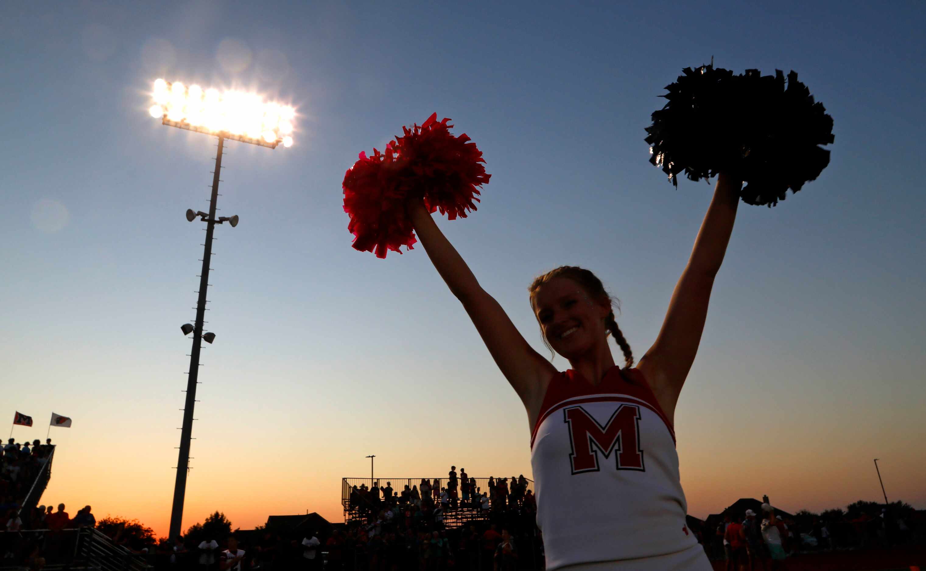 A Melissa High School cheerleader encourages her team before kickoff as Melissa High School...