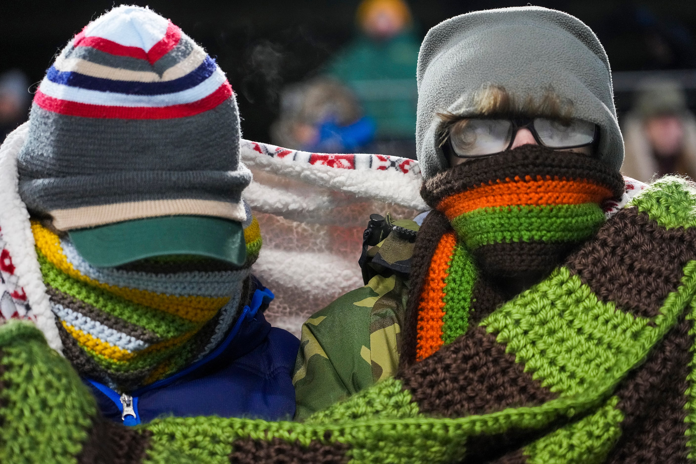 Ryan (left) and Ahren Dieguez from Helotes, Texas, bundle up against the cold before the...