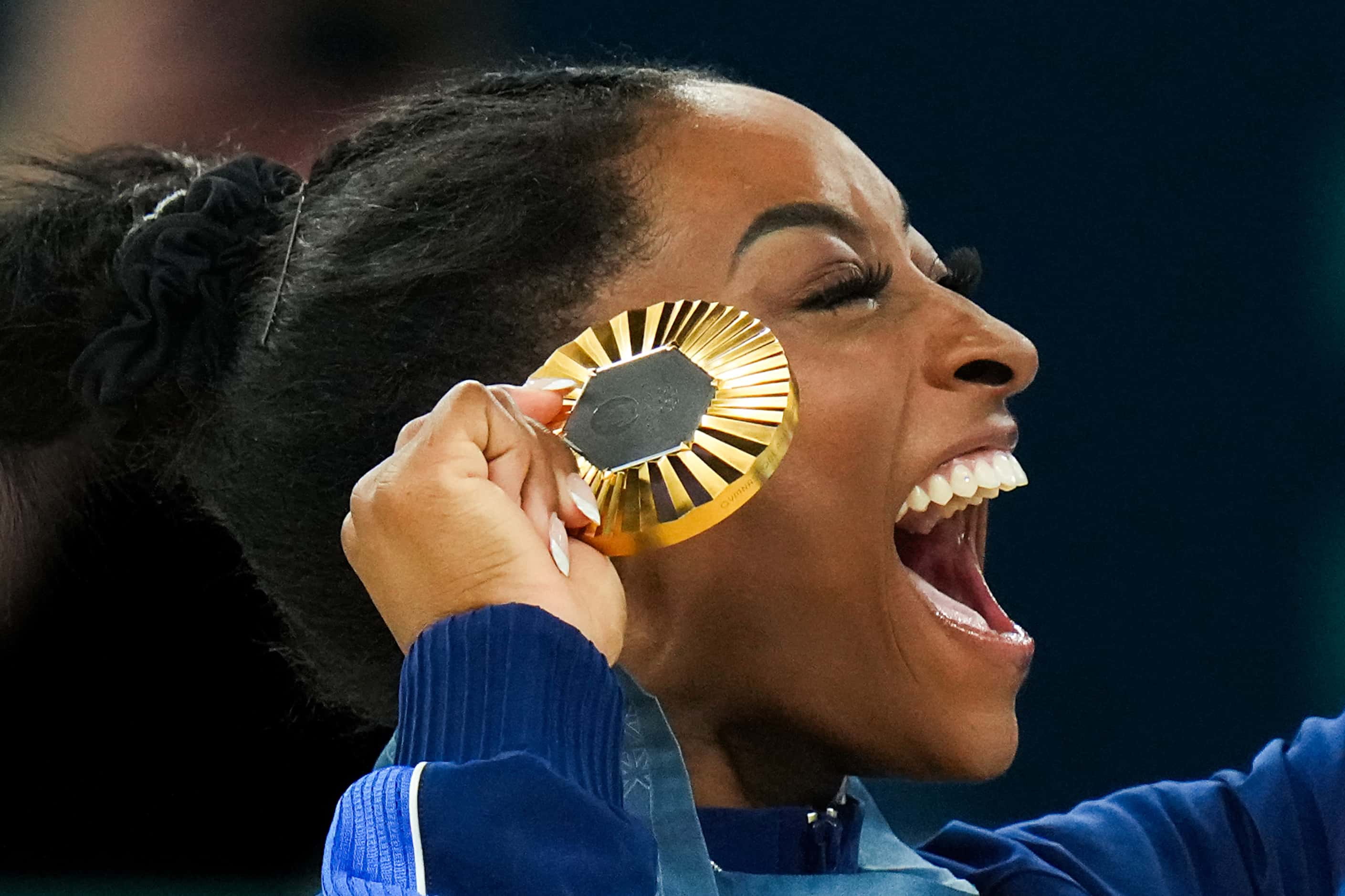 Simone Biles of the United States celebrates after receiving her gold medal for winning the...