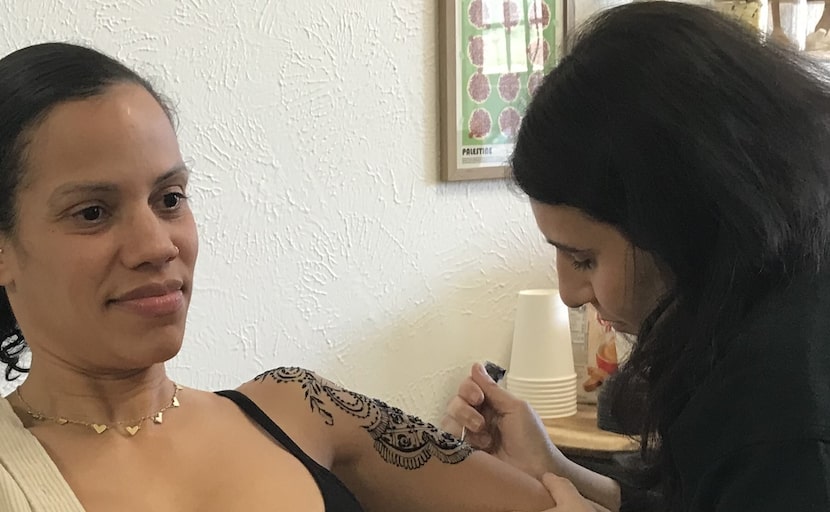 Marena Riyad applying jagua to customer Kami Harris. Jagua is a plant dye that s like henna,...