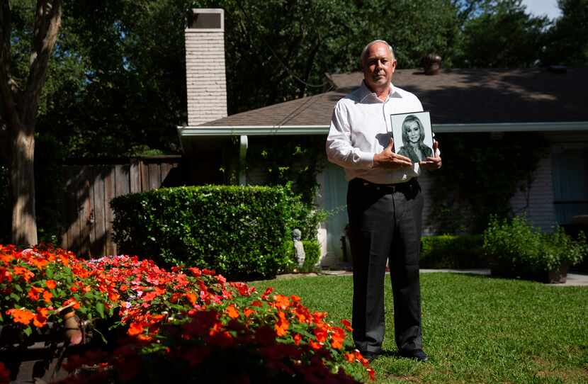 Robert Baker holds a photo of his wife, Leslie Squair Baker, in the backyard of his North...