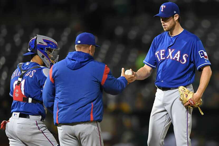 OAKLAND, CA - APRIL 04:  Manager  Jeff Banister #28 of the Texas Rangers takes the ball from...