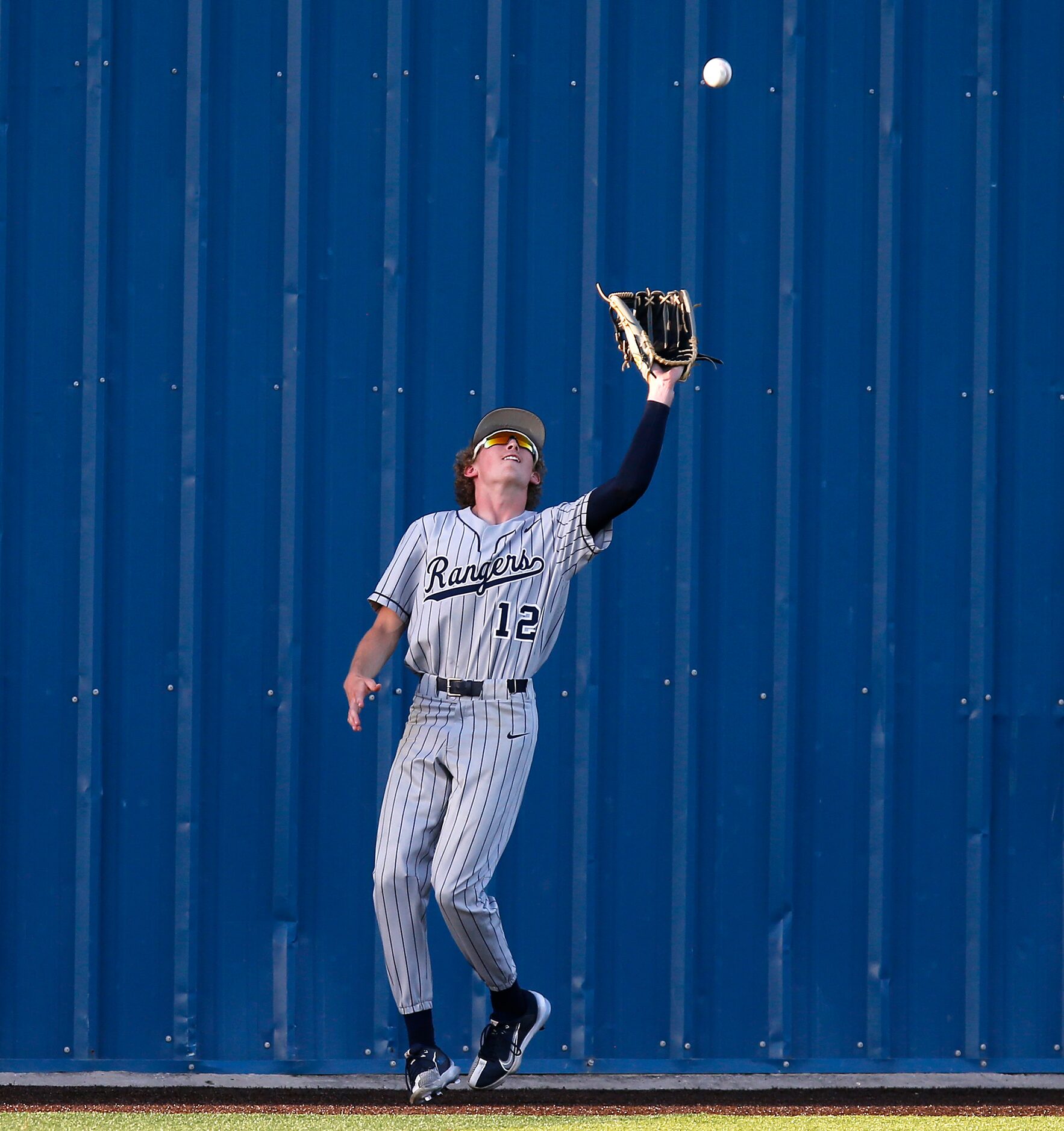 Lone Star High School left fielder Teague Rehwald (12) catches a fly ball at the wall for an...