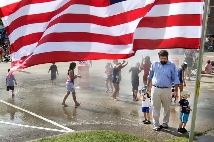 Framed by an American Flag, Jacob Wallace, of Midlothian, accompanies his 2-year-old sons,...