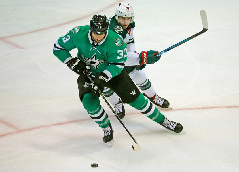 Dallas Stars defenseman Marc Methot (33) tries to corral the puck in front of Minnesota Wild...
