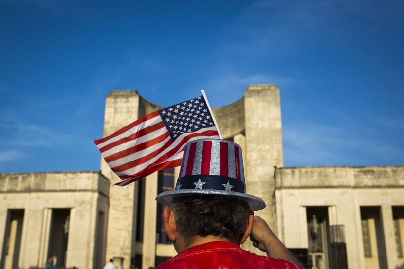 Bob Crawford waved the flag while listening to the Dallas Winds perform in front of the Hall...