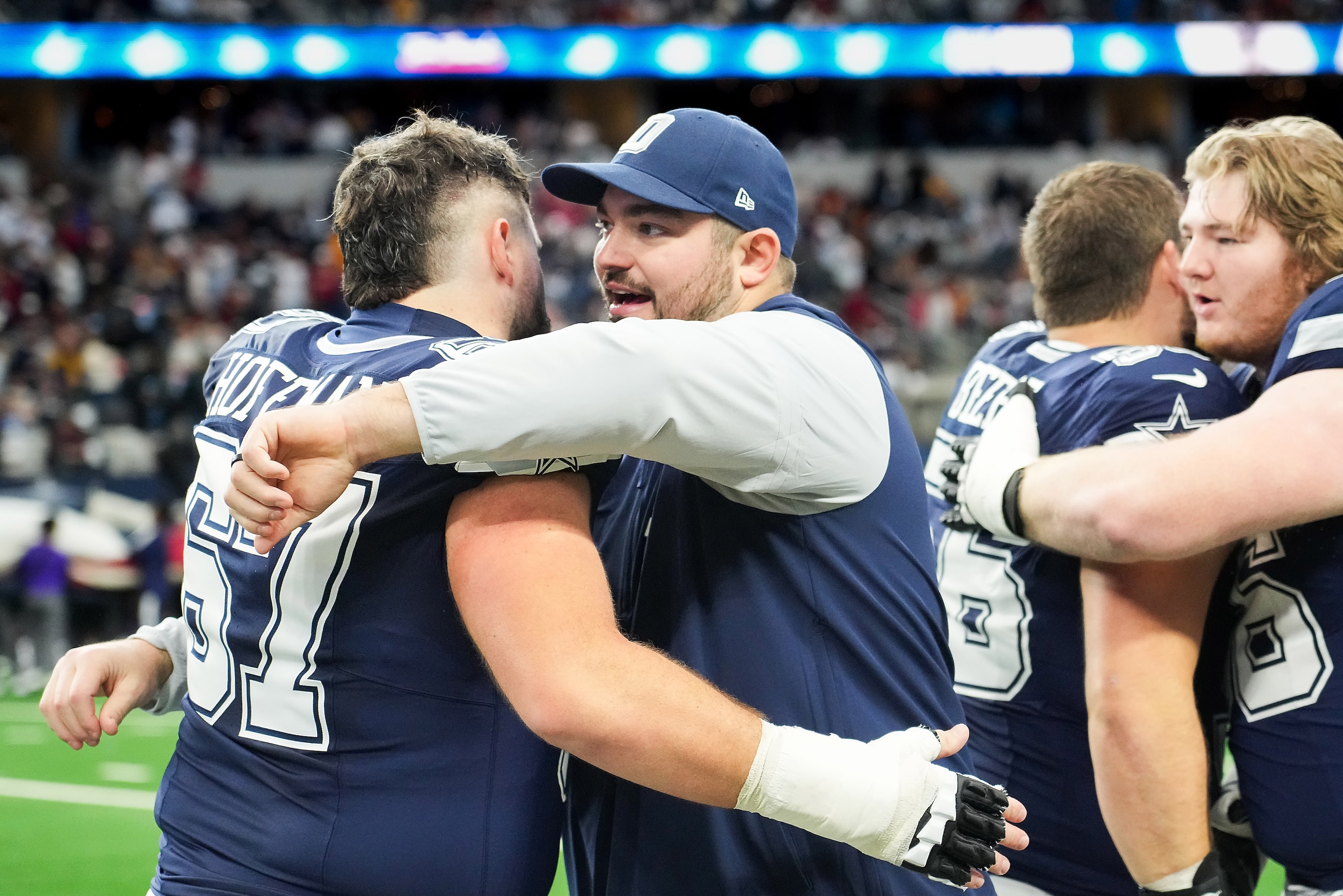 Dallas Cowboys guard Zack Martin (facing) hugs center Brock Hoffman (67) before an NFL...