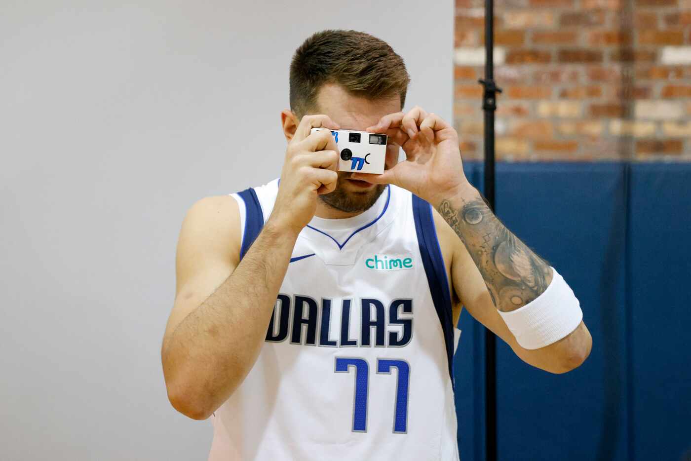 Dallas Mavericks guard Luka Doncic (77) takes a photo with a disposable camera during media...