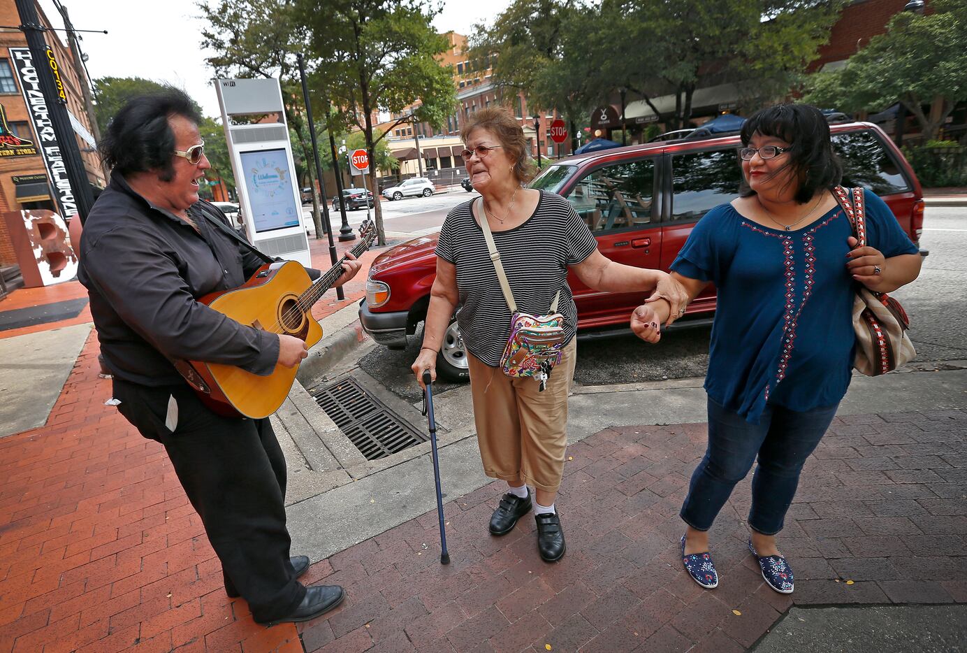Elvis impersonator Phil Sneed (left) performs an Elvis song for Maria Mendoza (right) and...
