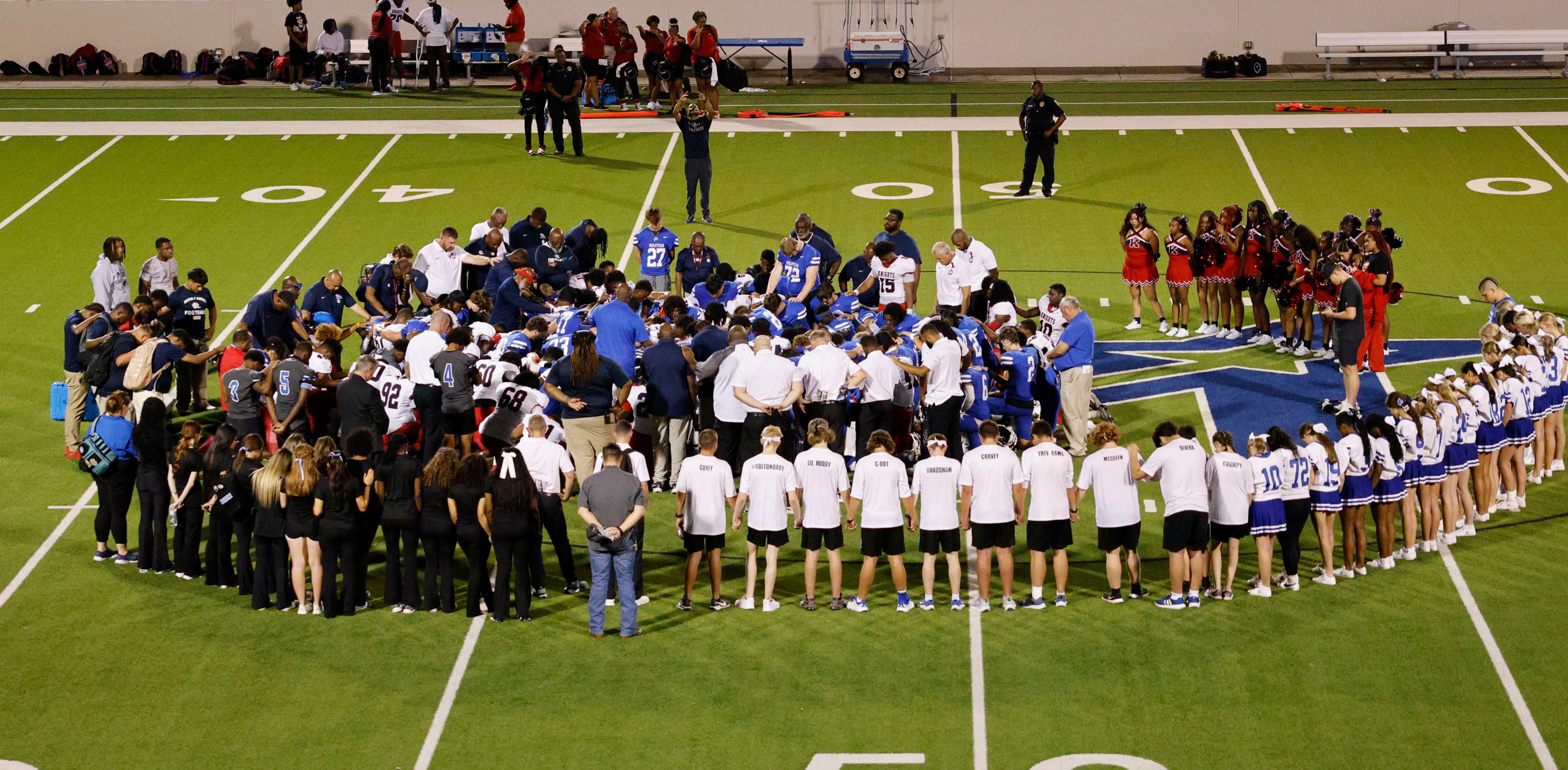 Both Kimball and Midlothian players pray together for Kimball JV football player David...