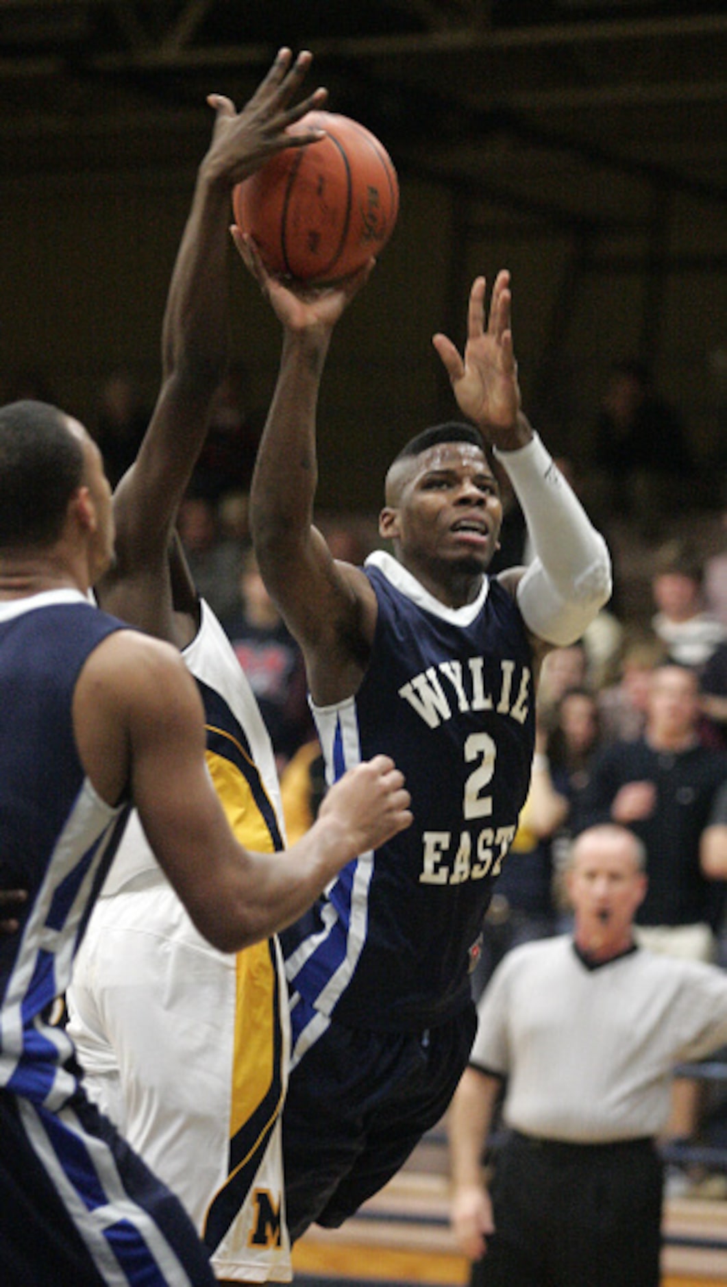 Wylie East High School's Kevon Mack (2) makes a shot attempt while falling forward against...