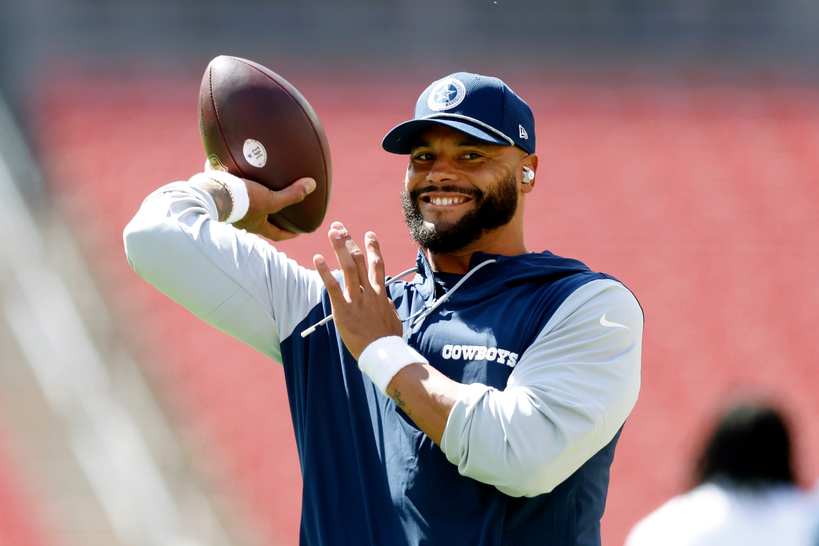 Dallas Cowboys quarterback Dak Prescott smiles as he warms up before a game against the...