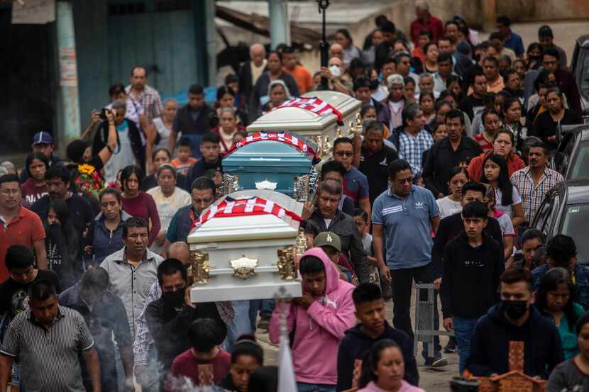 People carry the remains of Jair Valencia, Misael Olivares and Yovani Valencia for a funeral...