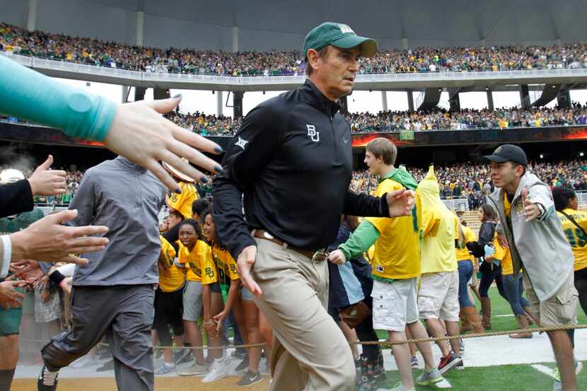 Baylor Bears head coach Art Briles runs through the line during introductions before a game...
