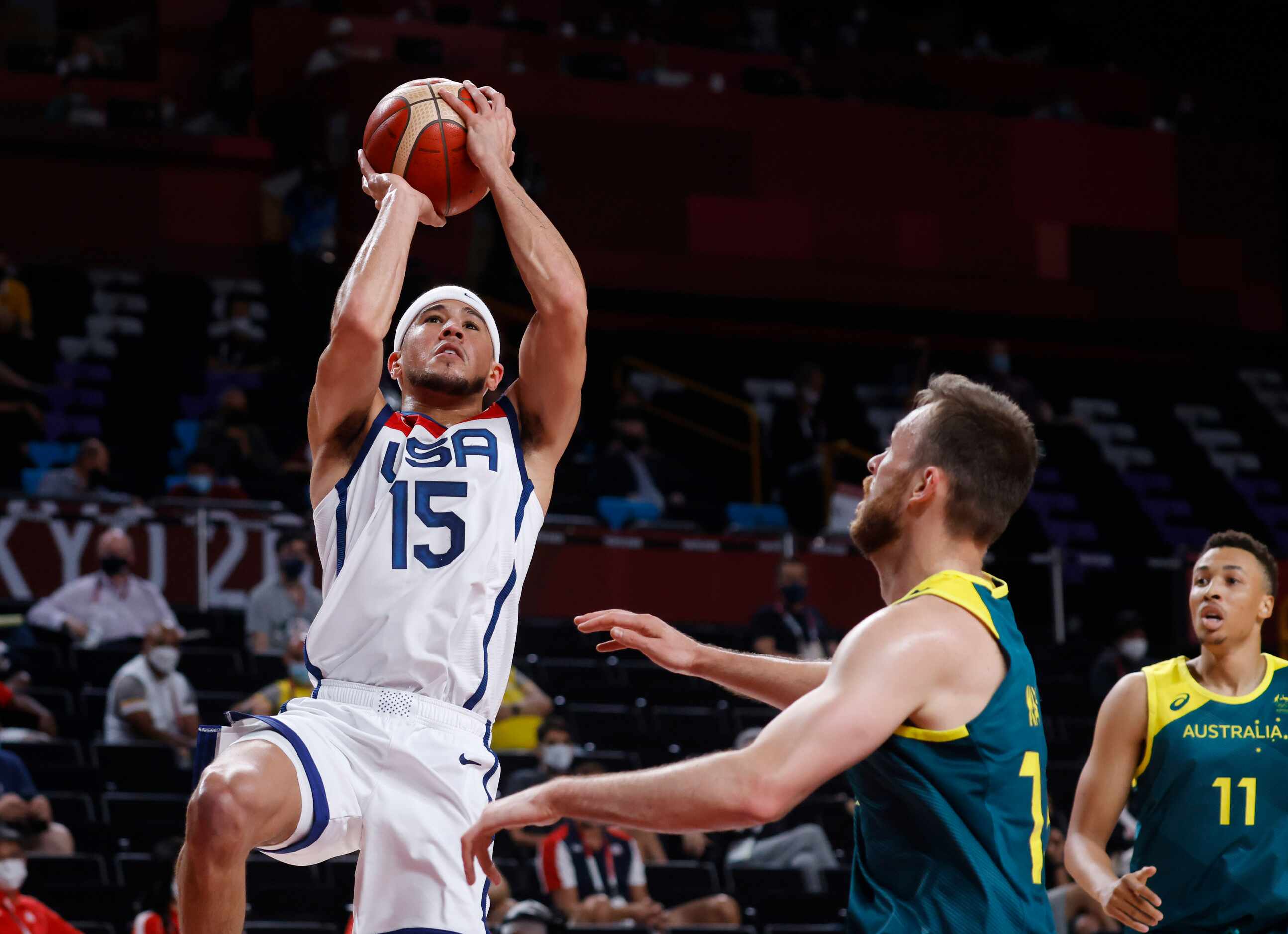 USA’s Devin Booker attempts a shot in front of 
Australia’s Nic Kay (15) during the first...